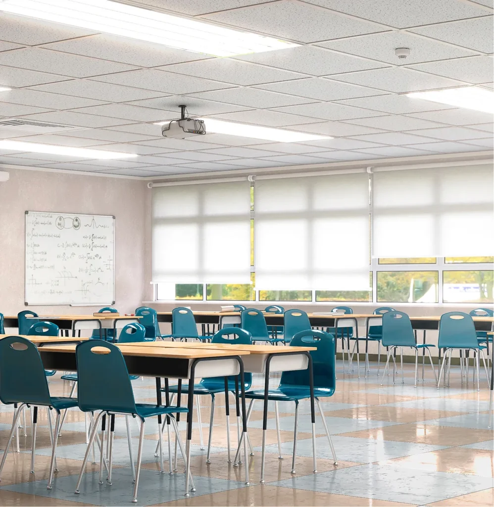 Empty classroom with teal chairs and tables, illustrating physical security compliance frameworks for schools