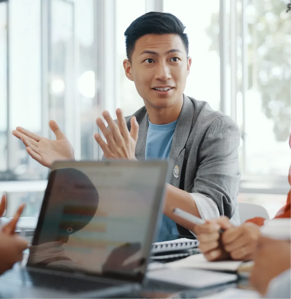 Man in a gray blazer gesturing in a team discussion, illustrating who uses Circadian Risk's executive dashboards