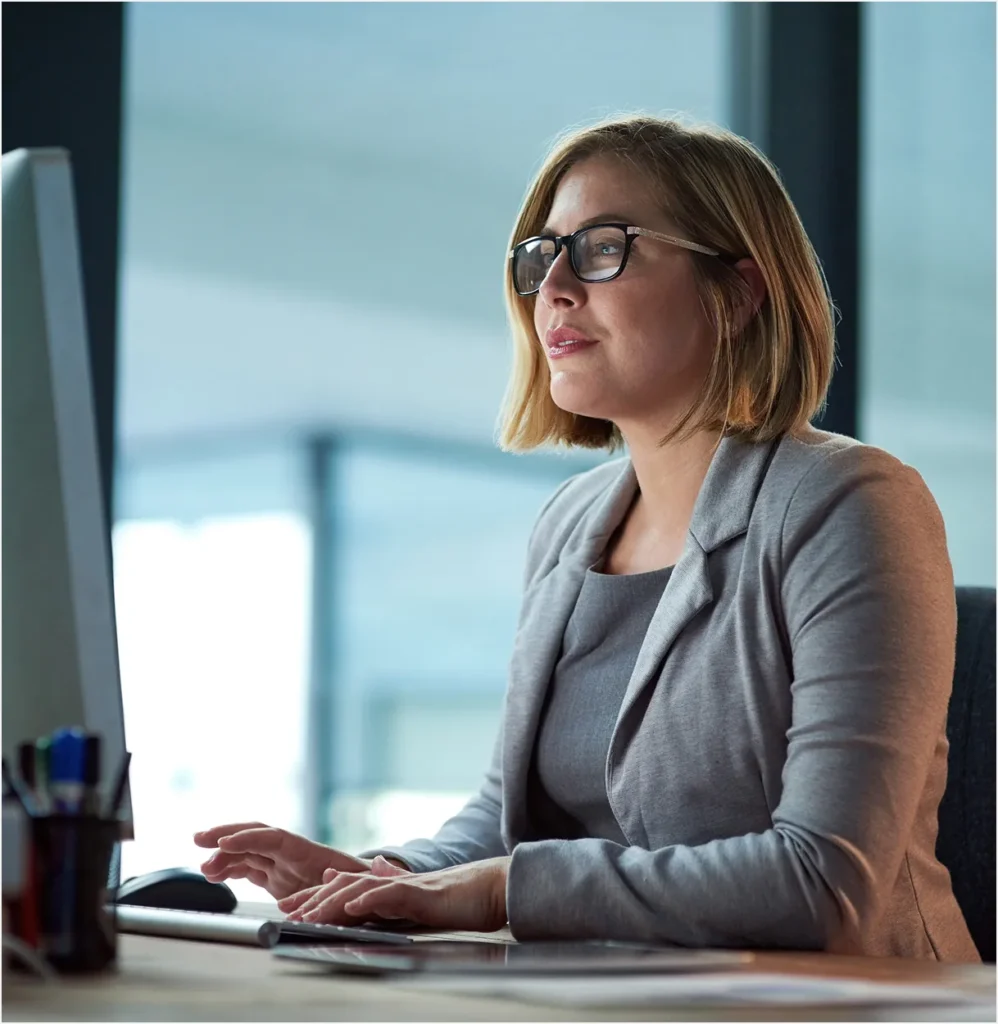 Businesswoman in glasses at a computer, a chief security officer with physical risk intelligence