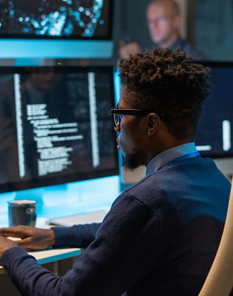 Security analyst at monitors in a security operations center, illustrating real-time risk visibility across every location