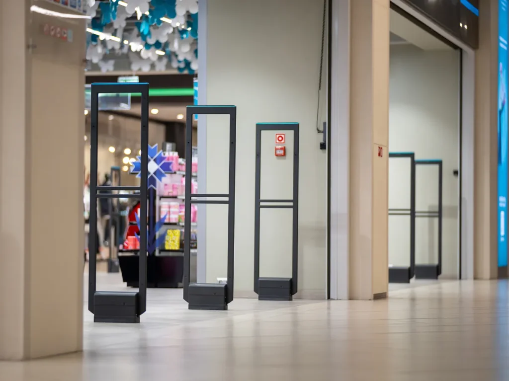 Anti-theft security pedestals at a store entrance in a shopping mall, illustrating retail physical security risk
