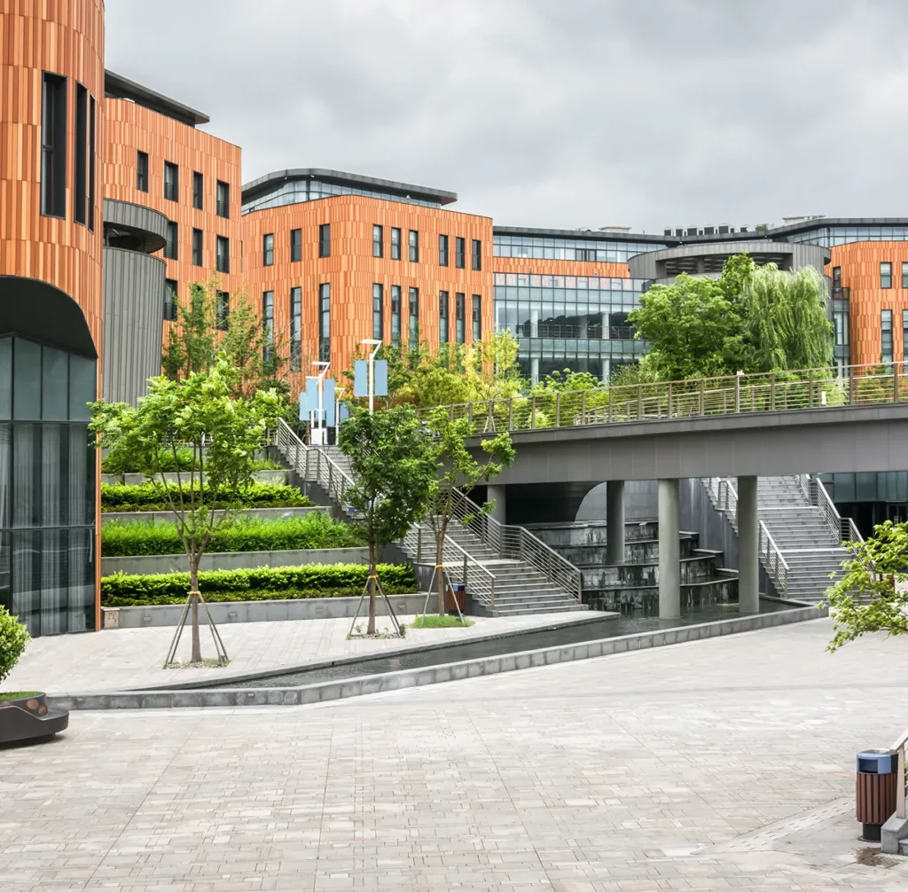 University campus courtyard with brick buildings and trees, illustrating physical security risk for schools and universities